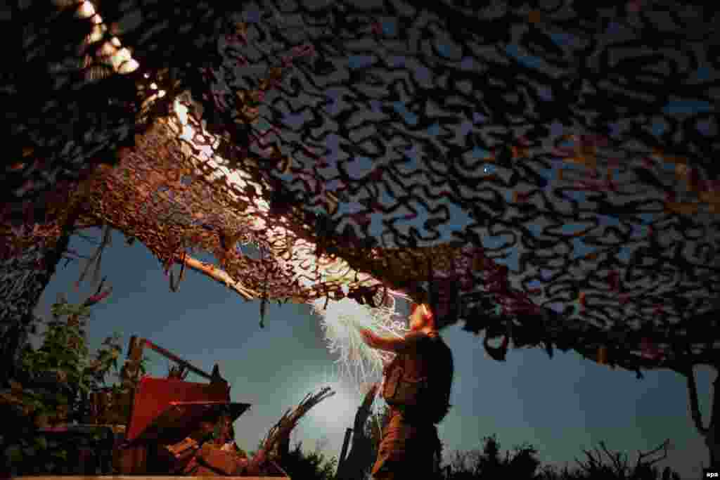 A Ukrainian serviceman launches a flare from his position on the front lines near Avdiyivka. (epa/Valeri Kvit)