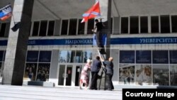 Флаги "ДНР" и "Новороссии" на здании Донецкого национального университета. Кадр из видеосюжета программы "Подробности"