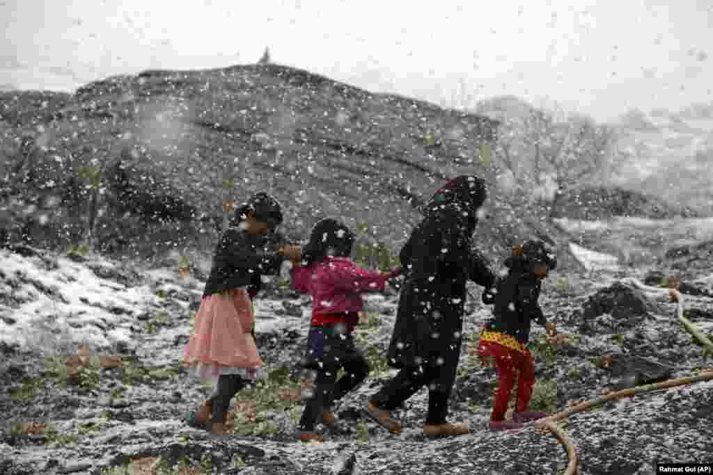 Afghan children walk during a snowfall on the outskirts of Kabul. (AP/Rahmat Gul)