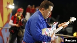Президент Уго Чавес сайлау науқаны кезіндегі жиында гитара шертіп тұр. Сулия штаты, Венесуэла, 30 қыркүйек 2012 жыл.