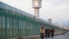 Workers walk by the perimeter fence of what is officially known as a vocational-skills education center in Dabancheng in China's Xinjiang Uyghur Autonomous Region in 2018.