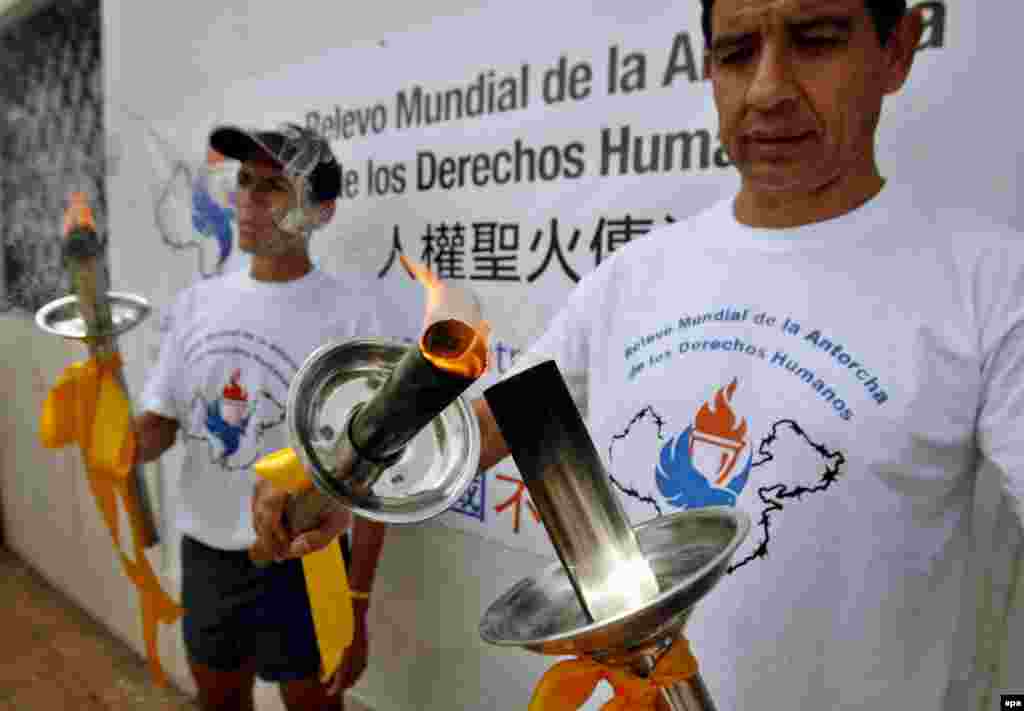 Argentina -- rgentinean Human Rights activists participate in the taking over of the 'Human Rights torch', a symbolical action compared with the Olympics torch, in front of the China's embassy in Buenos Aires, Argentina on 27Mar2008
