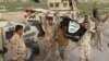 Iraqi pro-government forces hold up an Islamic State (IS) group flag and flash the V-sign during a military operation against IS near Amriyat al-Fallujah, west of the capital Baghdad in the Anbar province, May 2016.