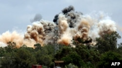 Пламя в результате авиабомбардировки сил НАТО близ столицы Ливии Триполи. 24 мая 2011 года. 