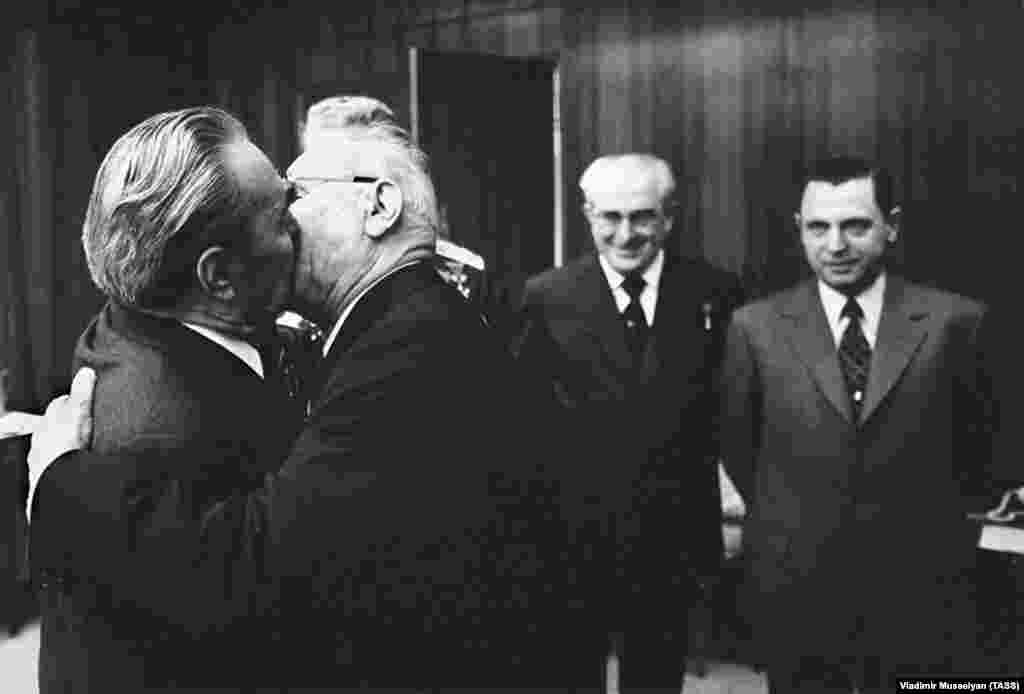 As Brezhnev locks lips with Nikolai Podgorny in the Kremlin in 1975, two elder statesmen (right) suffer instant demotion to third and fourth wheels.