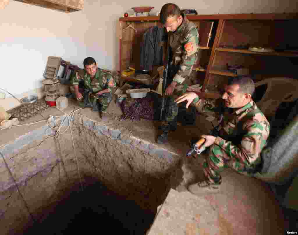 Kurdish Peshmerga fighters stand around a tunnel used by Islamic State militants on the outskirts of Bartila, east of Mosul, during an operation to retake the city. (Reuters/Azad Lashkari)