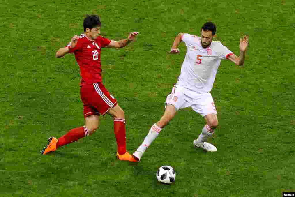 Soccer Football - World Cup - Group B - Iran vs Spain - Kazan Arena, Kazan, Russia - June 20, 2018 Spain's Sergio Busquets in action with Iran's Sardar Azmoun REUTERS/John Sibley