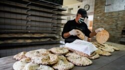 Radnik sa zaštitnom opremom pakuje ramazanske somune u jednoj od pekara u Sarajevu, 23 april 2020.