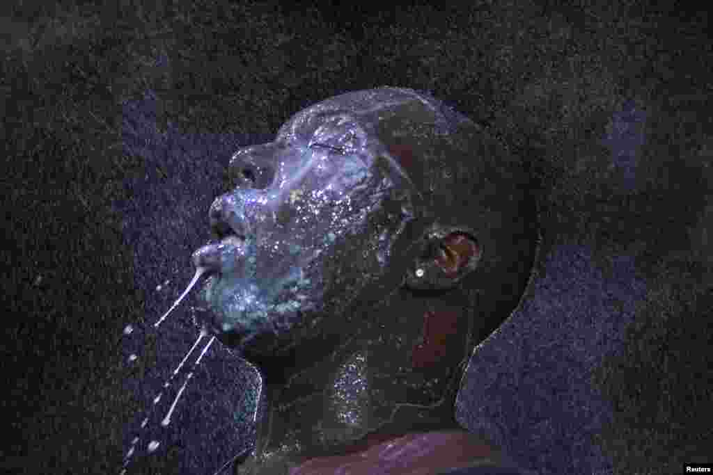A man is doused with milk and sprayed with mist after being hit by an eye irritant from security forces trying to disperse demonstrators protesting against the shooting of unarmed black teen Michael Brown in Ferguson, Missouri, on August 20. (Reuters/Adrees Latif)