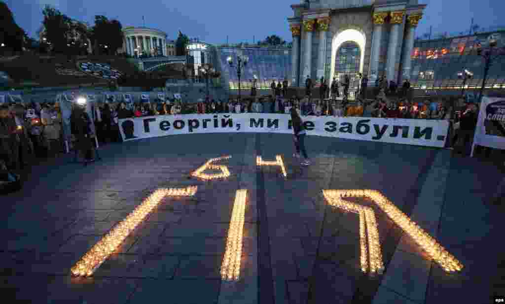 Ukrainians stand around candles forming the name of Ukrainian journalist Heorhiy Gongadze on Independence Square in Kyiv on the 15th anniversary of his disappearance on September 16. His decapitated body was found later, buried in a shallow grave in a wooded area outside of Kyiv.(epa/Roman Pilipey)