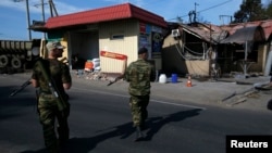 Pro-Russian separatists man a checkpoint near a destroyed building in the eastern Ukrainian town of Slovyansk on May 22.