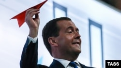 Премьер-министр России Дмитрий Медведев запускает бумажный самолет на церемонии закрытия Универсиады на стадионе "Казанская Арена", 17 июля 2013 года