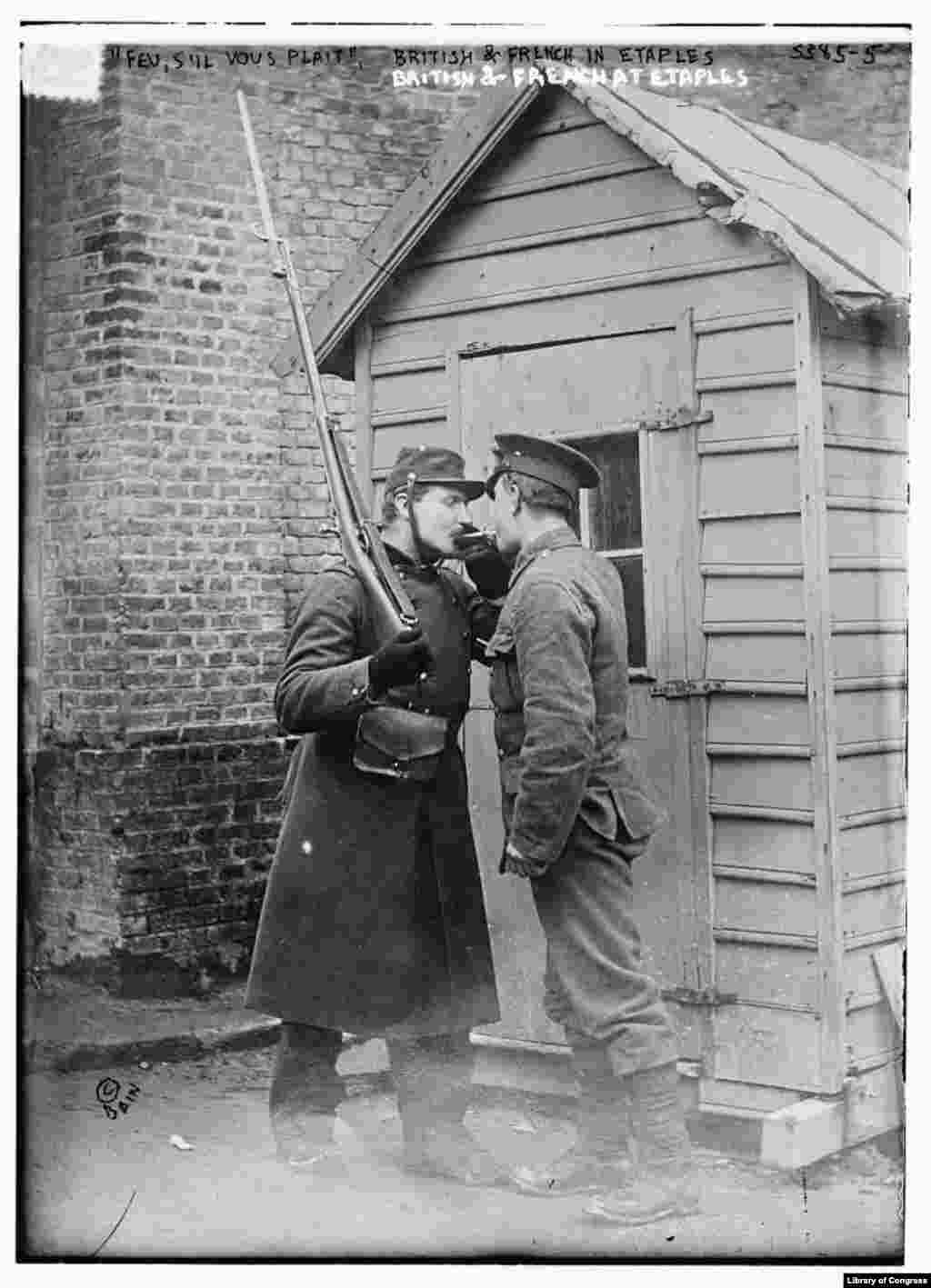 British and French soldiers light a cigarette at Etaples in northern France at the beginning of World War I. Although the source of the flu strain that devastated the world from 1918-1920 is disputed, many believe the pandemic began in this French military camp.