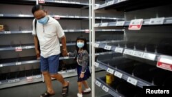 Чоловік із дитиною оглядають порожні полиці в супермаркеті, Сінгапур, 8 лютого 2020 року