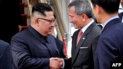 North Korean leader Kim Jong Un (left) is welcomed by Singapore's Foreign Minister Vivian Balakrishnan (center) upon his arrival on June 10.