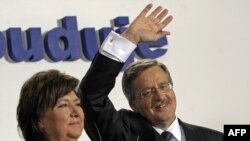 Bronislaw Komorowski (right) waves to supporters with his wife Anna after exit polls for the early presidential election in Warsaw on July 4.