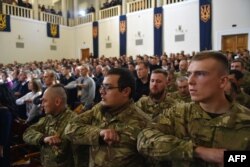Delegates of the new Ukrainian far-right political party "National Corps" sing the national anthem.