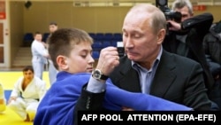 Президент России Владимир Путин показывает прием на открытой тренировке по дзюдо, 2012 год
