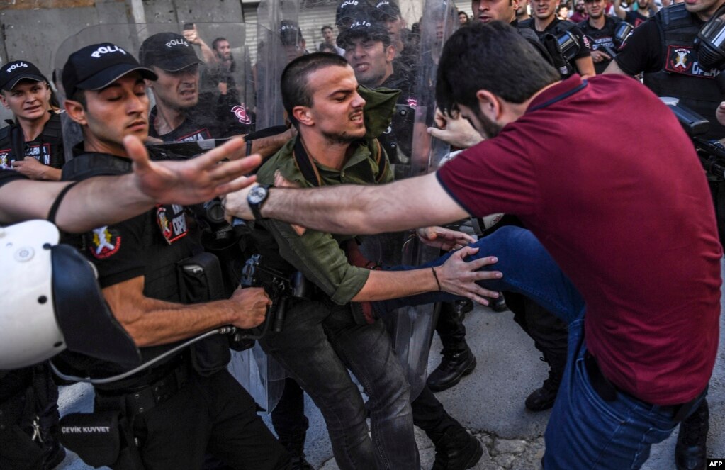 A plainclothes police officer kicks a member of a group of LGBT rights activist as Turkish police prevent them from going ahead with a gay-pride annual parade in Istanbul on June 25. (AFP/Bulent Kilic)