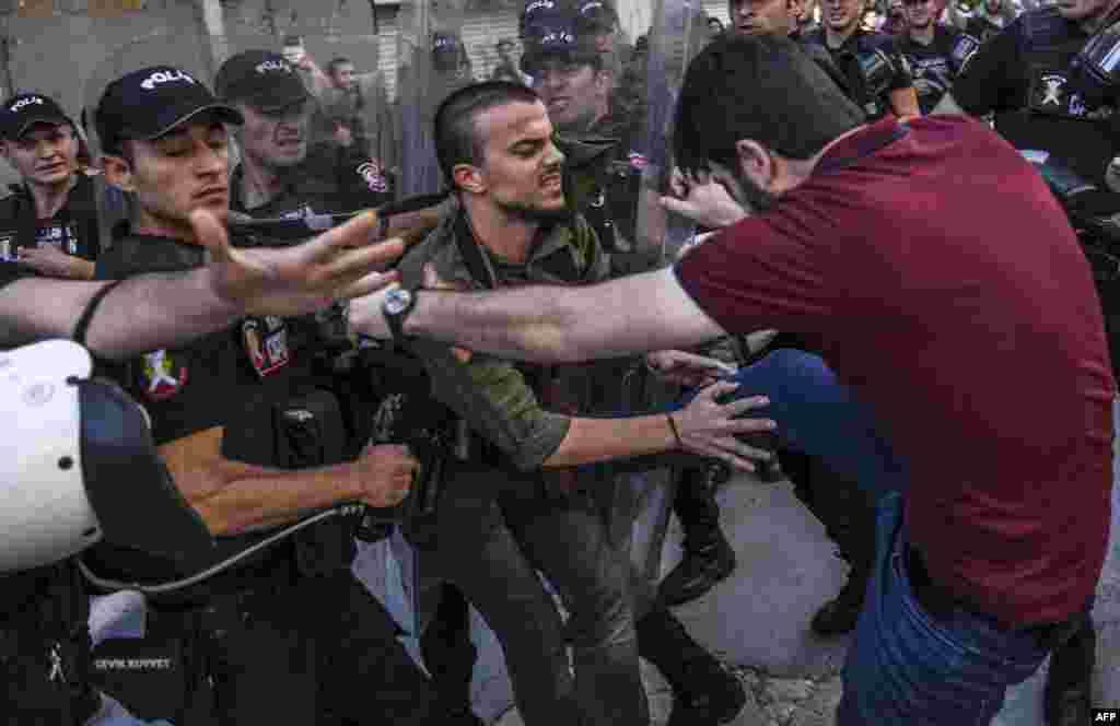 A plainclothes police officer kicks a member of a group of LGBT rights activist as Turkish police prevent them from going ahead with a gay-pride annual parade in Istanbul on June 25. (AFP/Bulent Kilic)