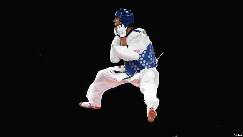 Afghanistan&#39;s Rohullah Nekpa jumps in celebration after winning his men&#39;s 68-kilogram bronze medal taekwondo match against Britain&#39;s Martin Stamper at the London Olympics. (Reuters/Darren Staples)