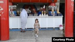 Abdrakhman in fatigues outside a Mosul juice bar