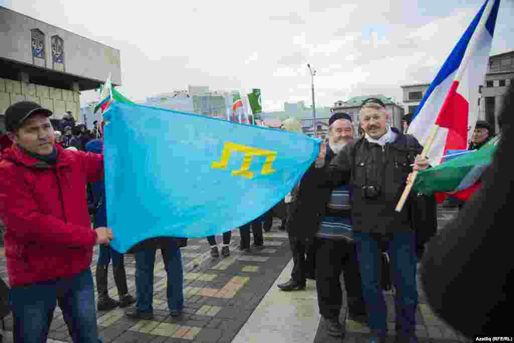 Присутствующие на митинге держат крымскотатарский флаг