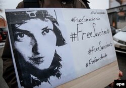 A woman holds a poster with the hashtag #FreeSavchenko and a portrait of Ukrainian pilot Nadia Savchenko during a rally in Kyiv on January 26 demanding her release from a Russian prison.