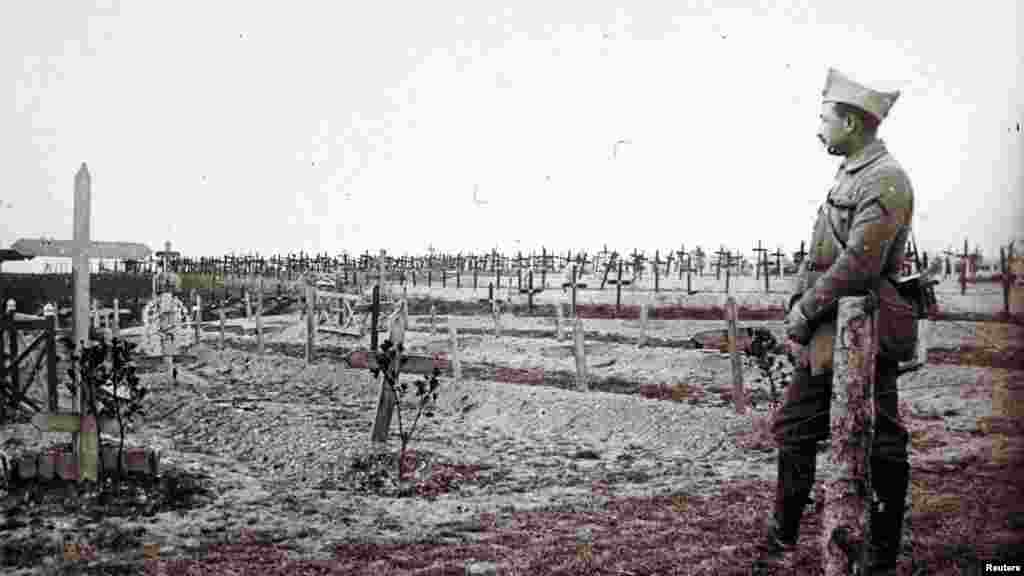 Французский офицер стоит у свежих могил солдат, убитых в Сен-Жан-сюр-Турб на фронте в Шампани. Восточная Франция, 19 декабря 1916 год