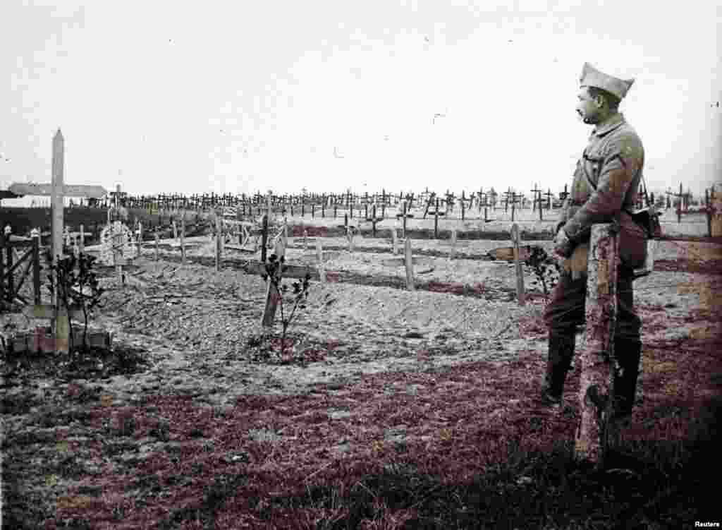 Францускі афіцэр стаіць каля магілаў нядаўна пахаваных салдатаў, якія загінулі на фронце на ўсходзе Францыі, 19 сьнежня 1916.