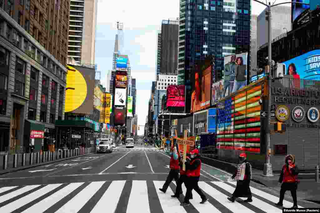 US - People walk around Times Square as the coronavirus disease (COVID-19) outbreak continues in New York, U.S., 21Mar2020