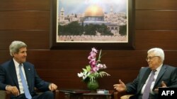 U.S. Secretary of State John Kerry (left) meets with Palestinian Authority President Mahmud Abbas on July 19 at the Mukataa compound in the West Bank city of Ramallah.