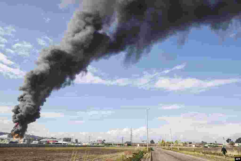 Heavy smoke billows from a fuel tank that caught fire at a refinery in the Israeli northern coastal city of Haifa on December 25. (AFP/Jack Guez)