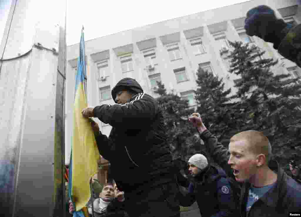 Проросійські активісти знімають український прапор біля міськради Сімферополя. 27 лютого 2014 року