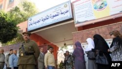 Egyptians stand in line outside a school turned into a polling station in Mansura, 120 kilometers north of Cairo.