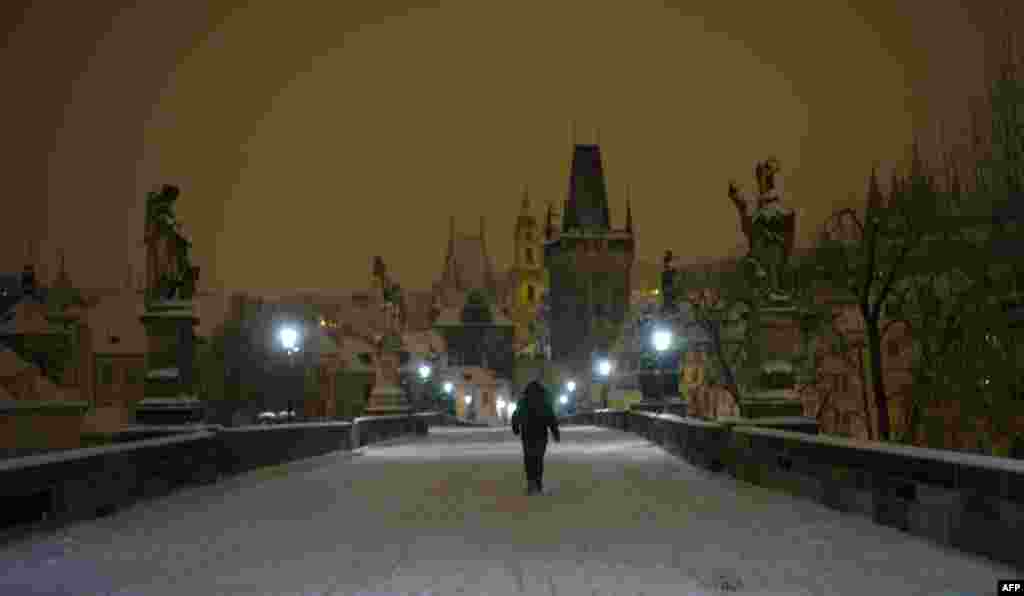 A man crosses the snow-covered Charles Bridge in Prague. (AFP/Michal Cizek)