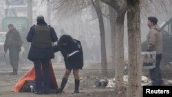 Мариупольдегі зымыран шабуылынан қаза тапқан адамның денесін тексеріп жатқандар. Украина, 24 қаңтар 2015 жыл.