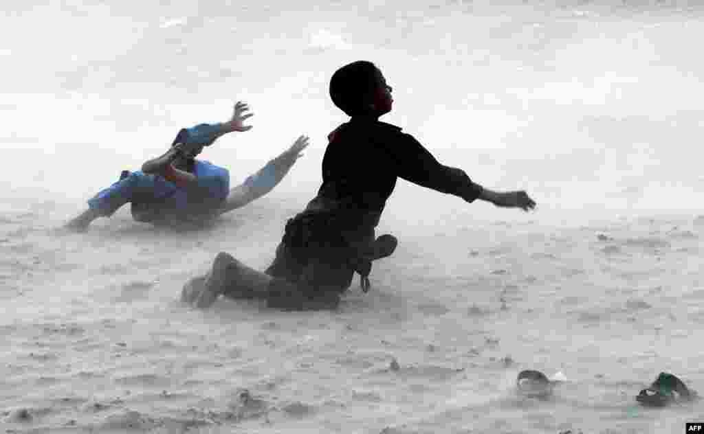 Children play during a dust storm on the banks of the Ravi River on the outskirts of Lahore, Pakistan. (AFP/Arif Ali)