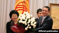 Роза Отунбаева получает букет роз в последний день президентства. Бишкек, 30 ноября 2011 года.
