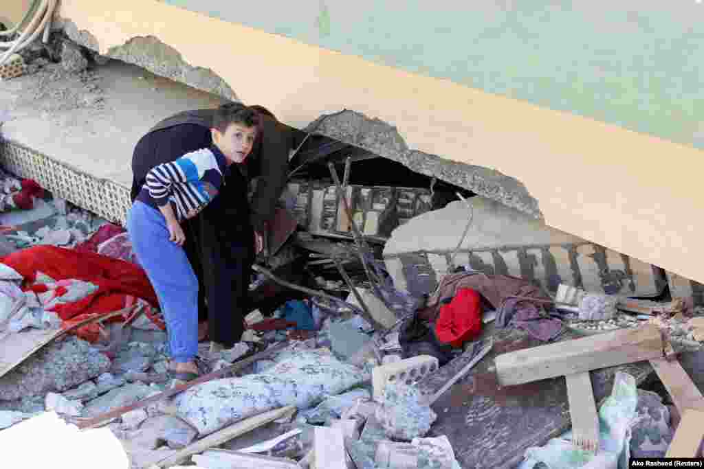 A boy looks at a damaged building in the town of Darbandikhan in northern Iraq.