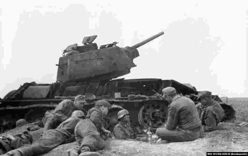 German troops of 3rd SS Panzer Division &quot;Totenkopf&quot; rest in front of a destroyed T-34 in Romania, 1944.