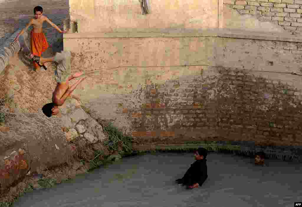 An Afghan boy somersaults into a river on the outskirts of Mazar-e Sharif. (AFP/Farshad Usyan)