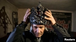 Blacksmith Viktor Mikhalev wears a metal crown made in the likeness of the Imperial Crown of Russia at his shop in Donetsk in eastern Ukraine. Mikhalev makes his handicrafts from the remains of ammunition left behind in the fighting between pro-Russian separatists and Ukrainian government forces. (Reuters/Maxim Shemetov)