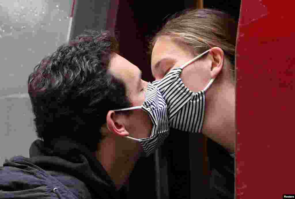 Пара цілується через маски. Дівчина повертається в Париж у перший день послаблення карантинних заходів у Бельгії (REUTERS/Yves Herman)