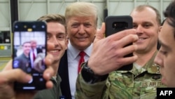 Президент США Дональд Трамп приветствует американских военных во время остановки на авиабазе Рамштайн в Германии, 27 декабря 2018 года