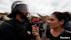 A woman gives a carnation to a Spanish Civil Guard officer outside a polling station in Sant Julia de Ramis, Spain on October 1, 2017.