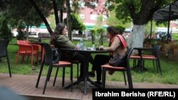 Dy vajza qëndrojnë në një kafiteri në Prishtinë gjatë pandemisë. 