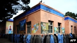 Afghan women queue outside a school to vote in presidential elections in the northwestern city of Herat on April 5, 2014.