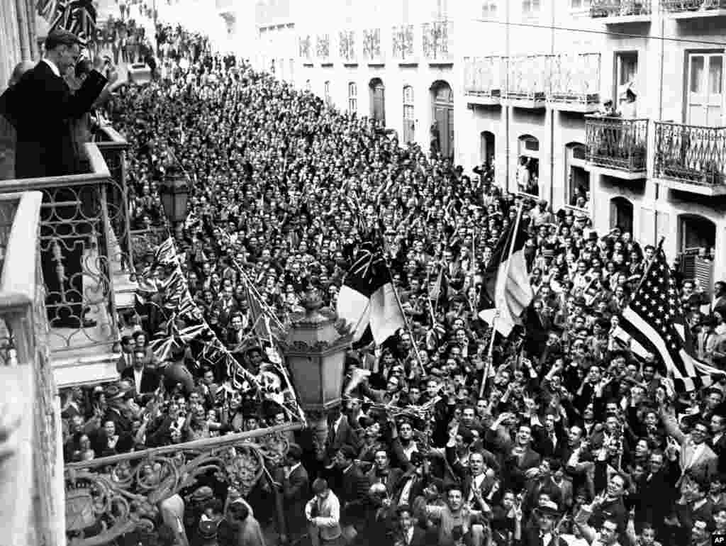 A crowd packs the street outside British and U.S. embassies in Lisbon.