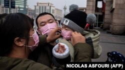 مادری در پکن به صورت کودک خود ماسک می‌زند: شمار قربانیان از ۱۳۰ نفر فراتر رفته است